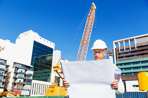 建筑工地的工程师建设者工程师建筑工人施工场景穿着带蓝图的安全背心